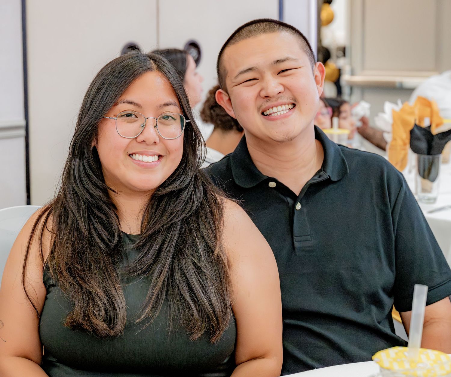 Young couple smiling together at a casual indoor gathering.