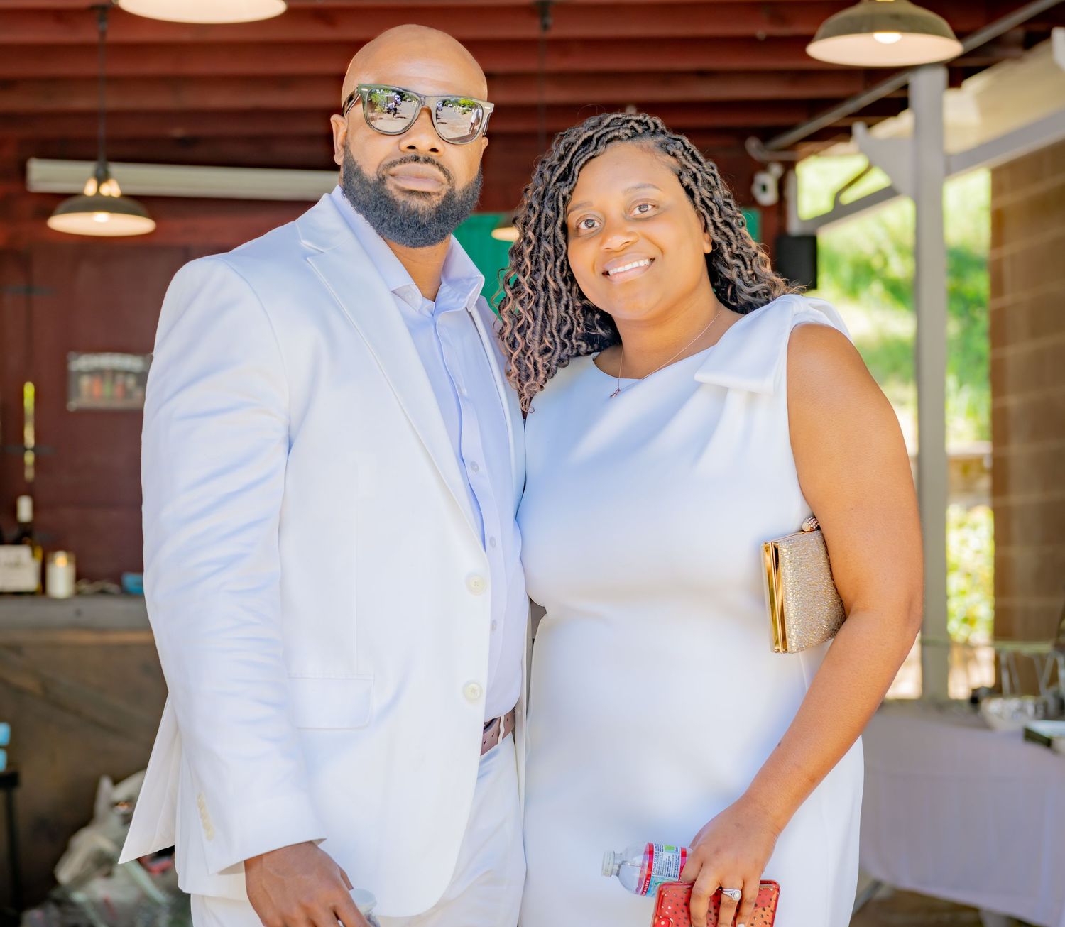 Couple posing together indoors at an elegant event, man in light blue suit.