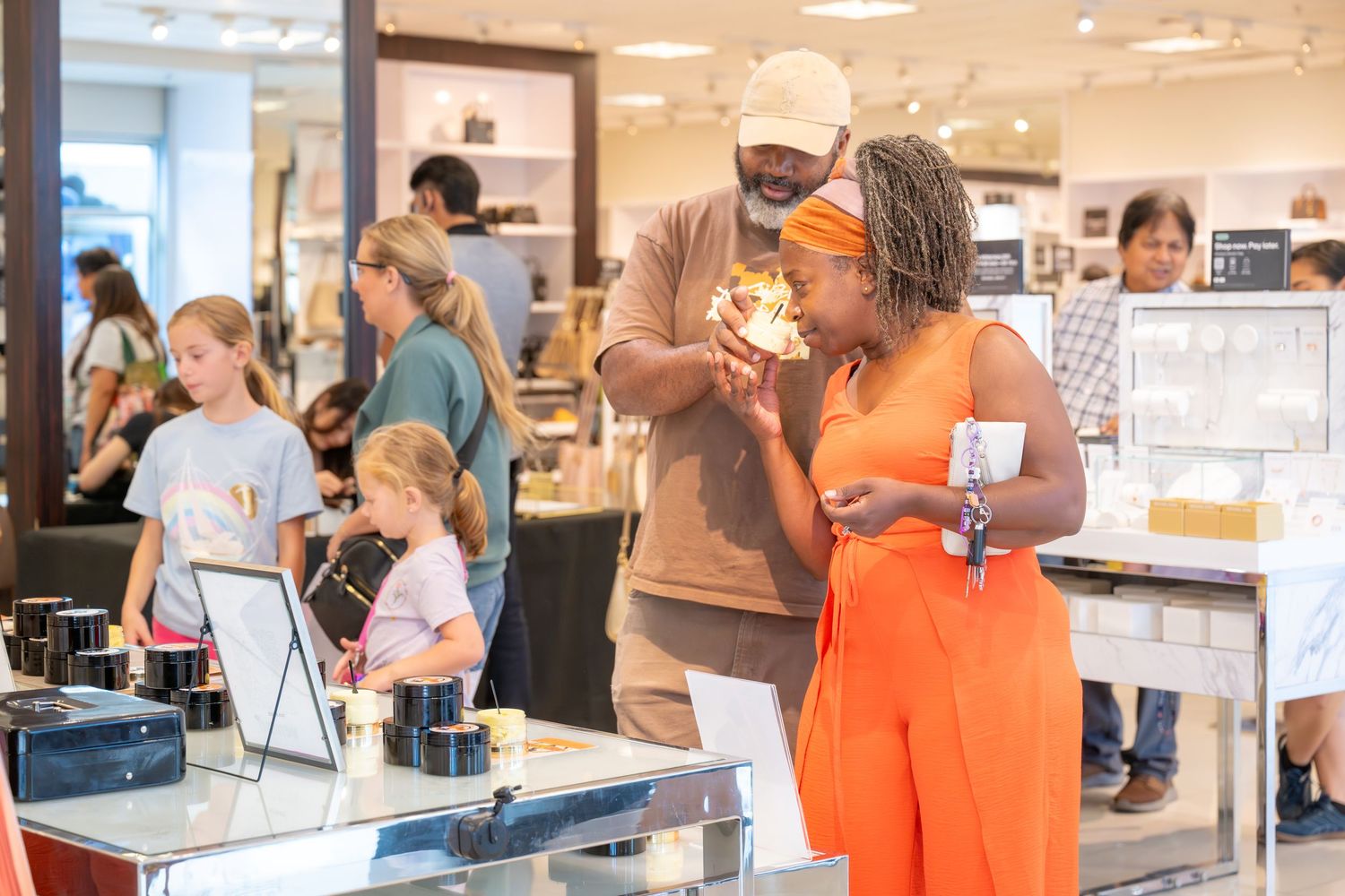 Couple examining a glowing item at a retail store display counter.
