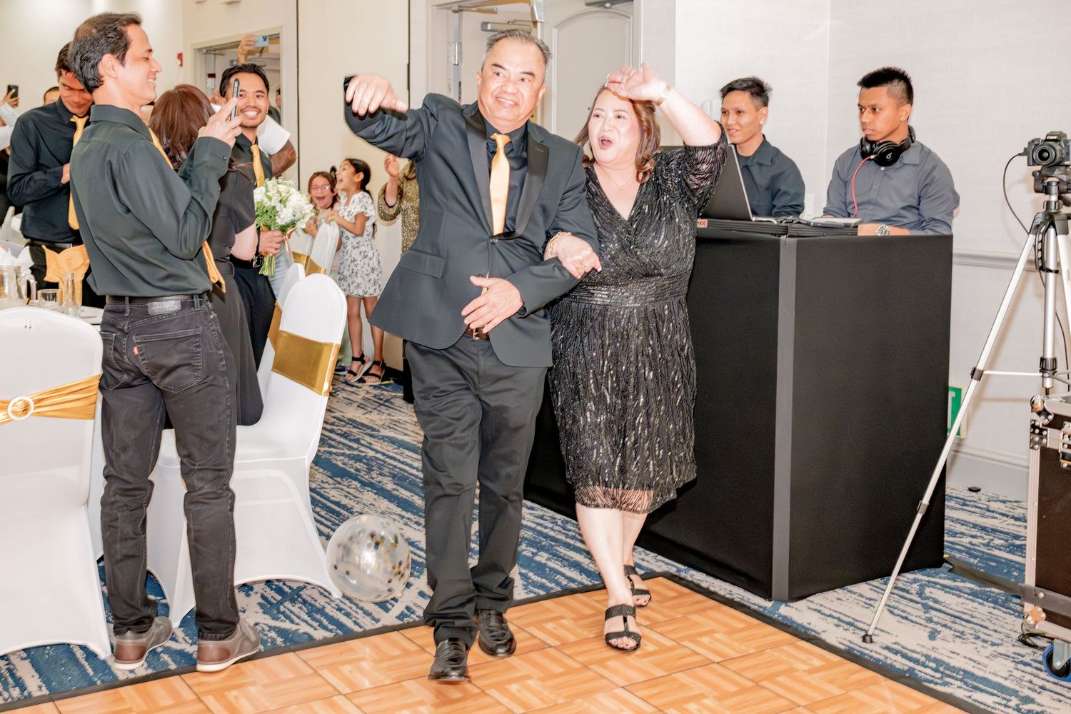 Couple dancing joyfully at an indoor celebration event.