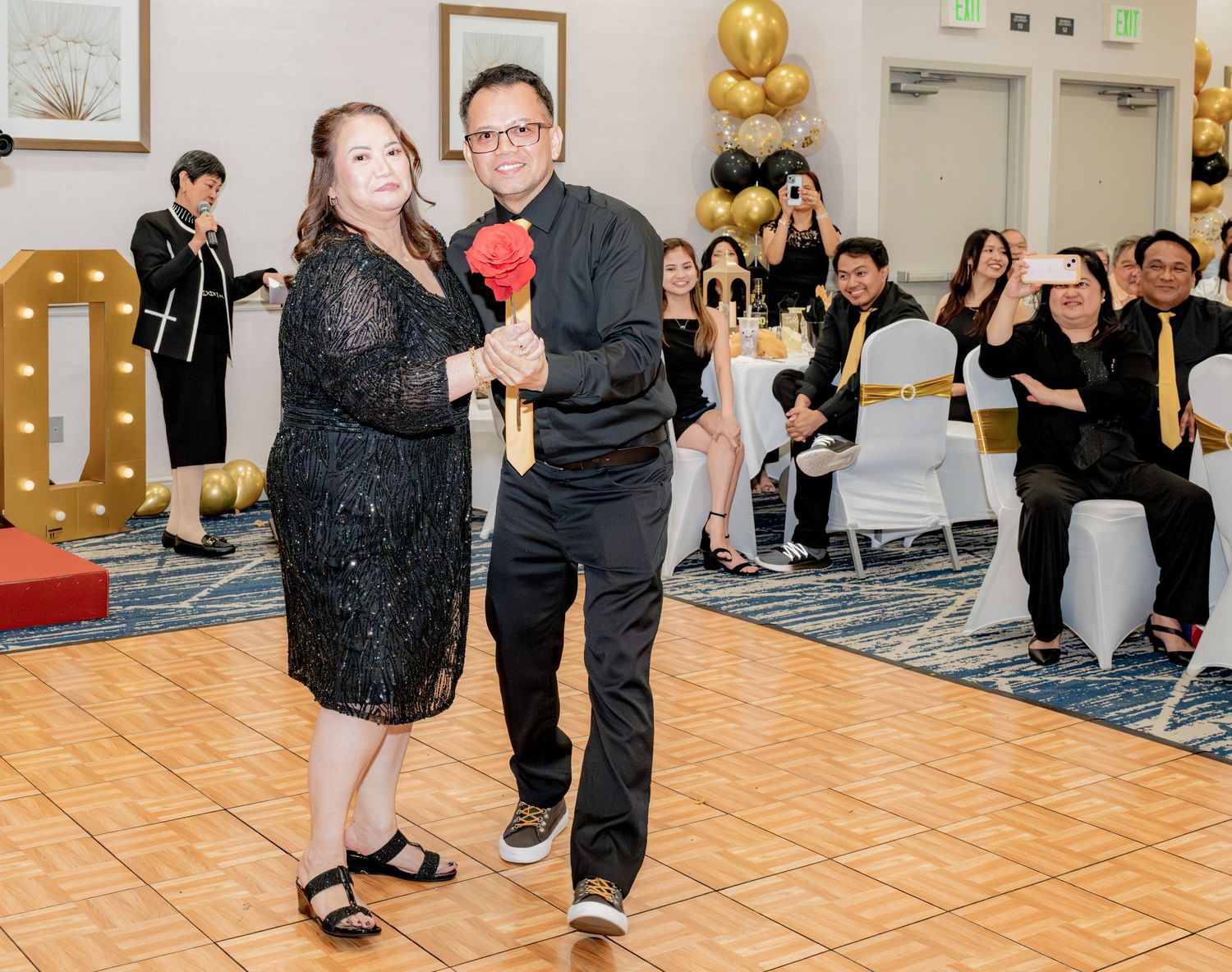 Couple dancing together on dance floor at elegant 60th birthday party celebration.