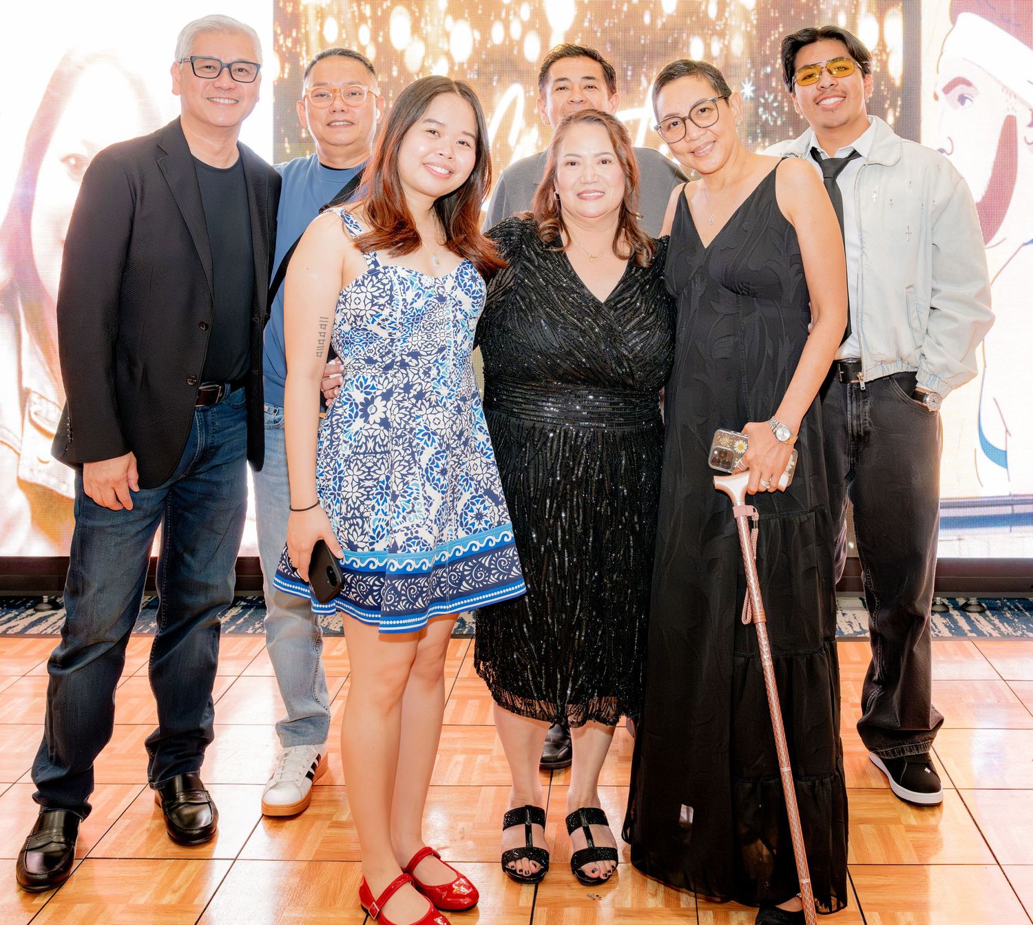 Family group posing together at a formal indoor celebration event.