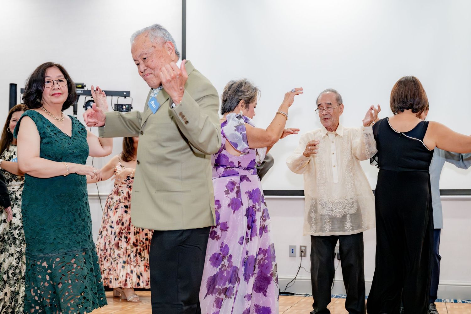 A group of elderly couples dancing together at a formal indoor social event or celebration.