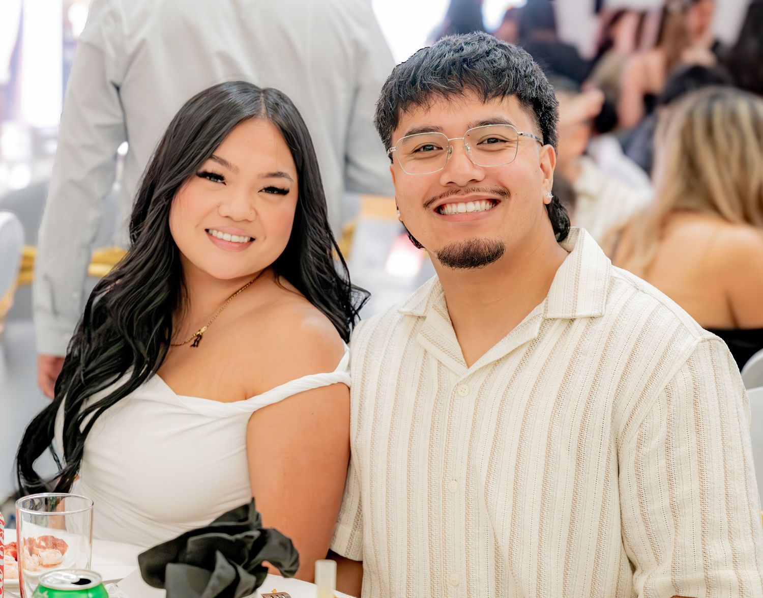 Young couple posing and smiling at a formal event.