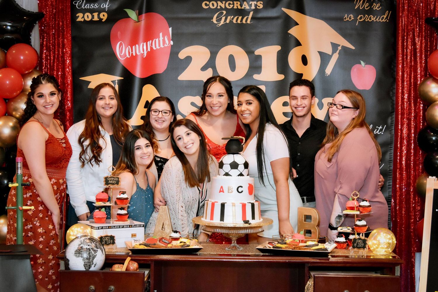 Group celebration event with red curtain backdrop and 2019 decorations in a festive party setting by FBM Studios in Ft Lauderdale Fl.