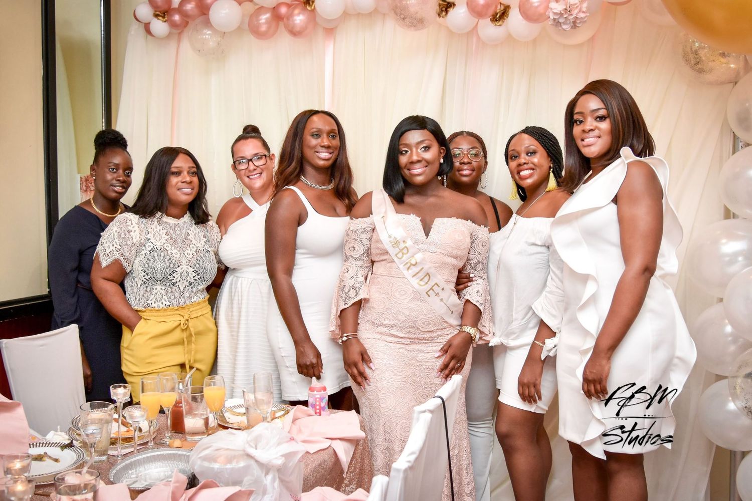Bridal shower celebration with group in white outfits against balloon backdrop by FBM Studios in Ft Lauderdale Fl.