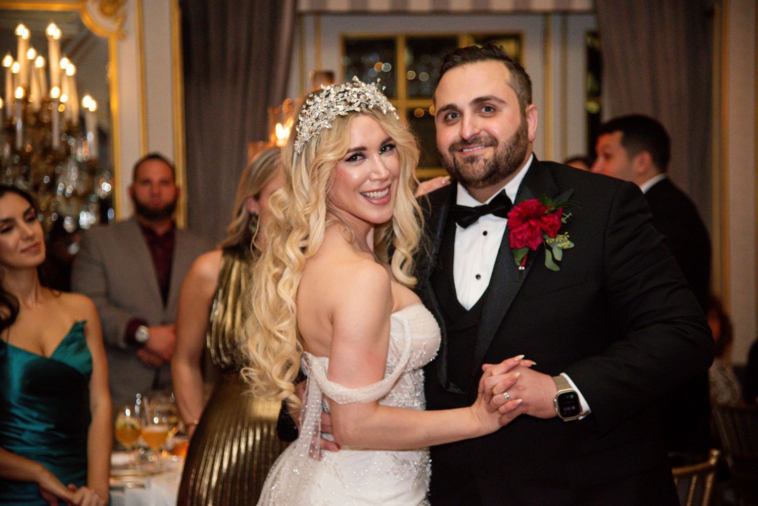 Elegant wedding reception scene with couples dancing in a grand ballroom with chandeliers and formal attire.