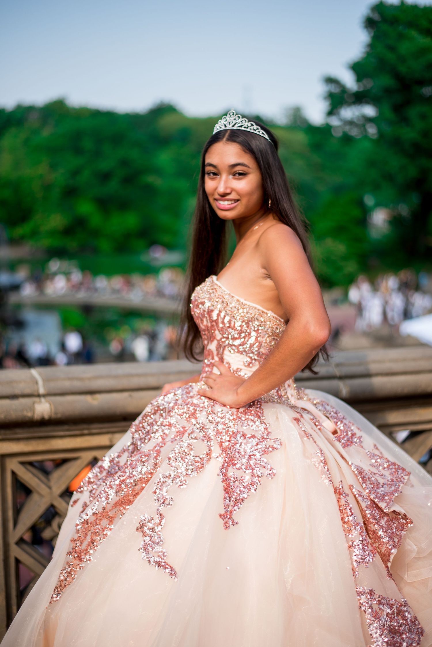 Young woman in rose gold sequin quinceañera ball gown and tiara poses gracefully outdoors by FBM Studios in Fort Lauderdale Florida.