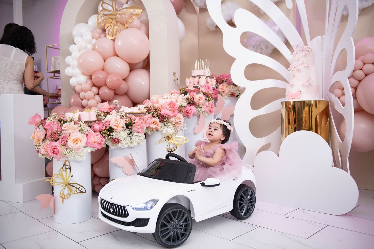 Luxurious pink butterfly-themed party setup with toy car and balloon decorations by FBM Studios in Ft Lauderdale Fl.