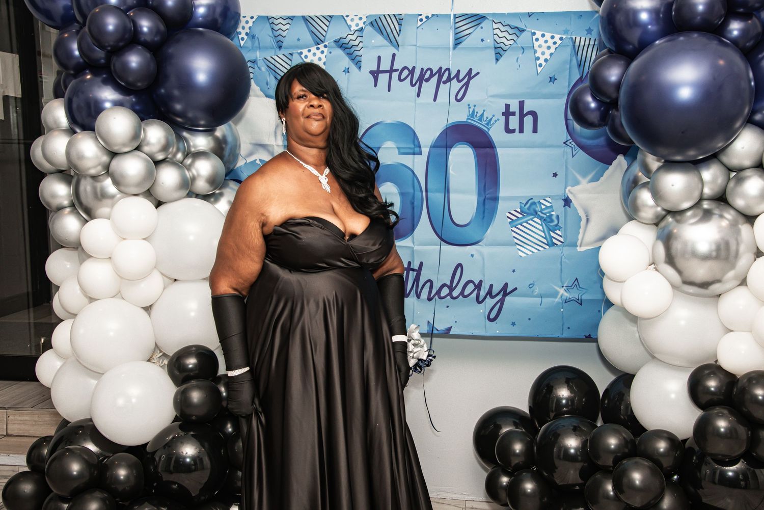 A celebration setup with black and white balloon arches framing a blue 50th birthday banner by FBM Studios in Ft Lauderdale Florida.