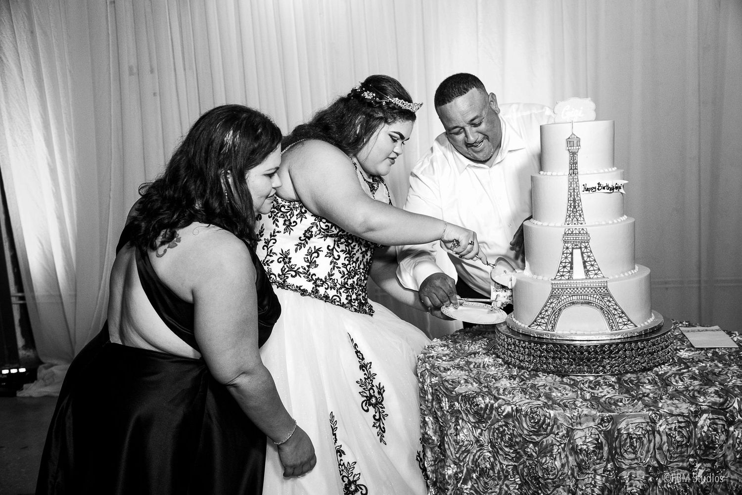 Black and white photo of bride and groom cutting a wedding cake with Eiffel Tower topper at reception by FBM Studios in Fort Lauderdale Fl