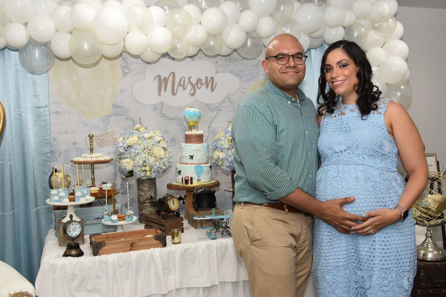 A baby shower celebration with white and blue balloon decorations, floral arrangements, and elegant table settings. by FBM Studios in FL