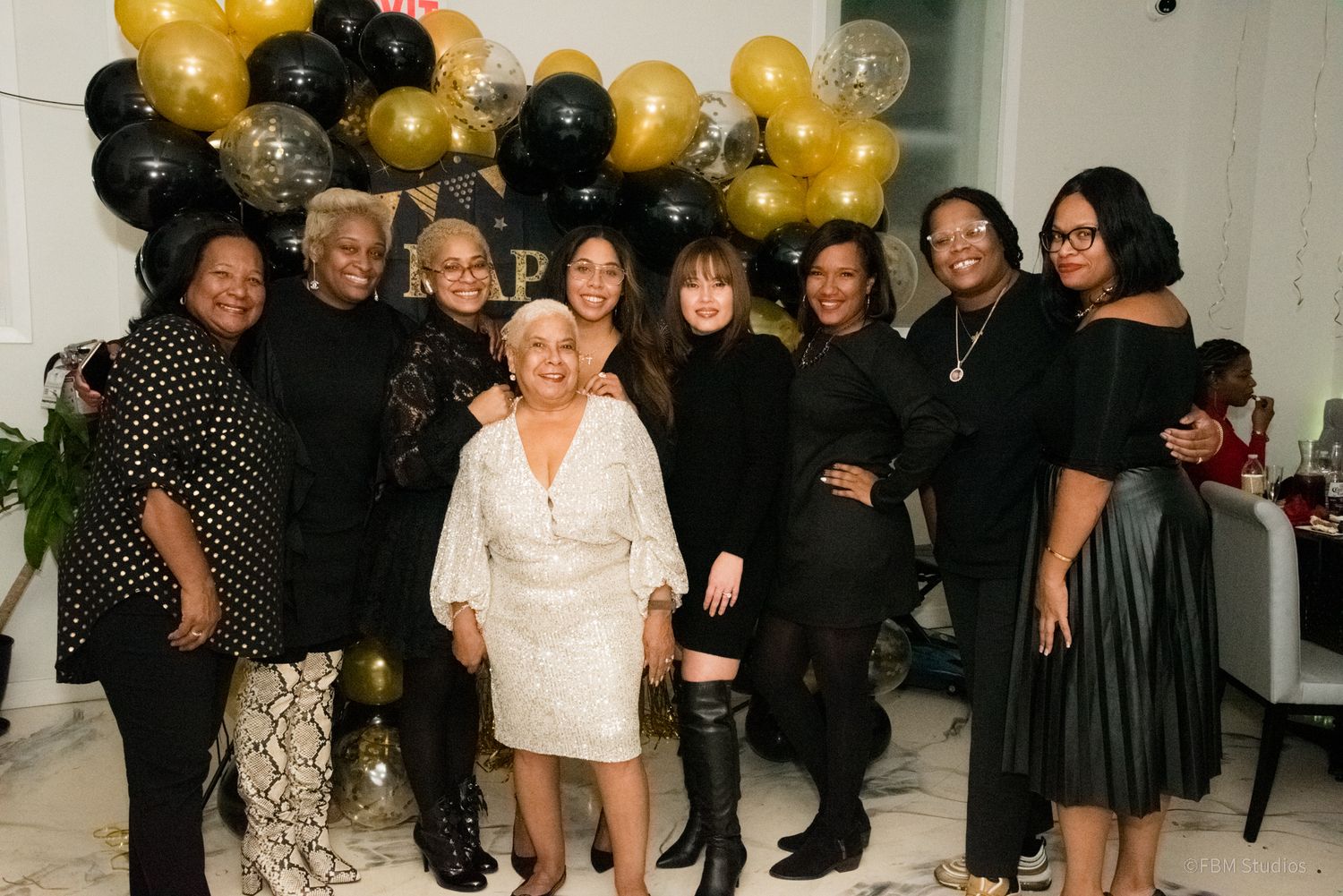 A celebratory party scene with black and gold balloons decorating the space as people gather for an event by FBM Studios in Fort Lauderdale