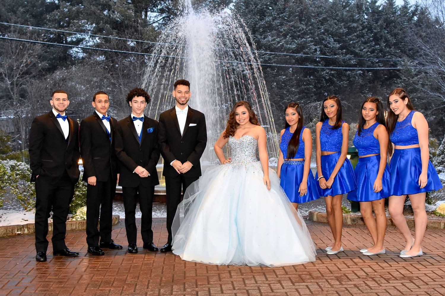 Formal attire pose before a fountain, girls in blue dresses and boys in tuxedos at quince by FBM Studios in Fort Lauderdale