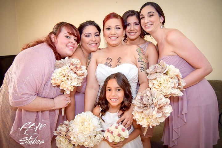 Bridesmaids in pink dresses hold cream-colored bouquets during wedding celebrations.