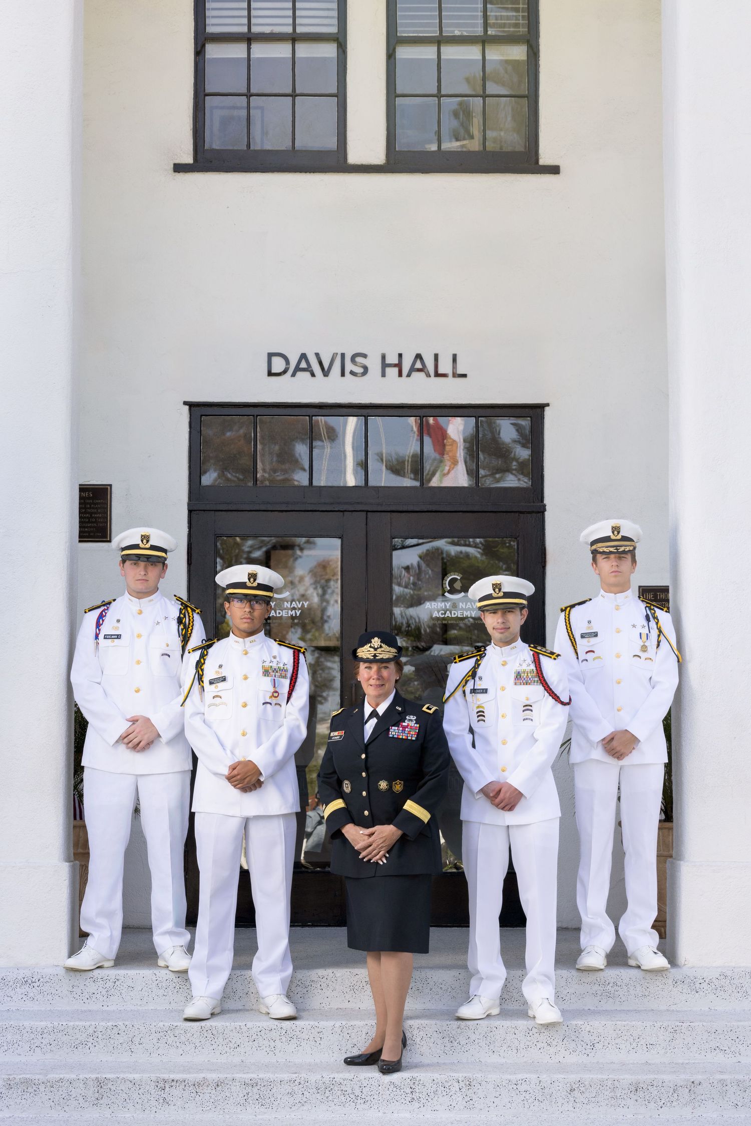 Five military officers in dress uniforms pose on steps outside Davis Hall building.