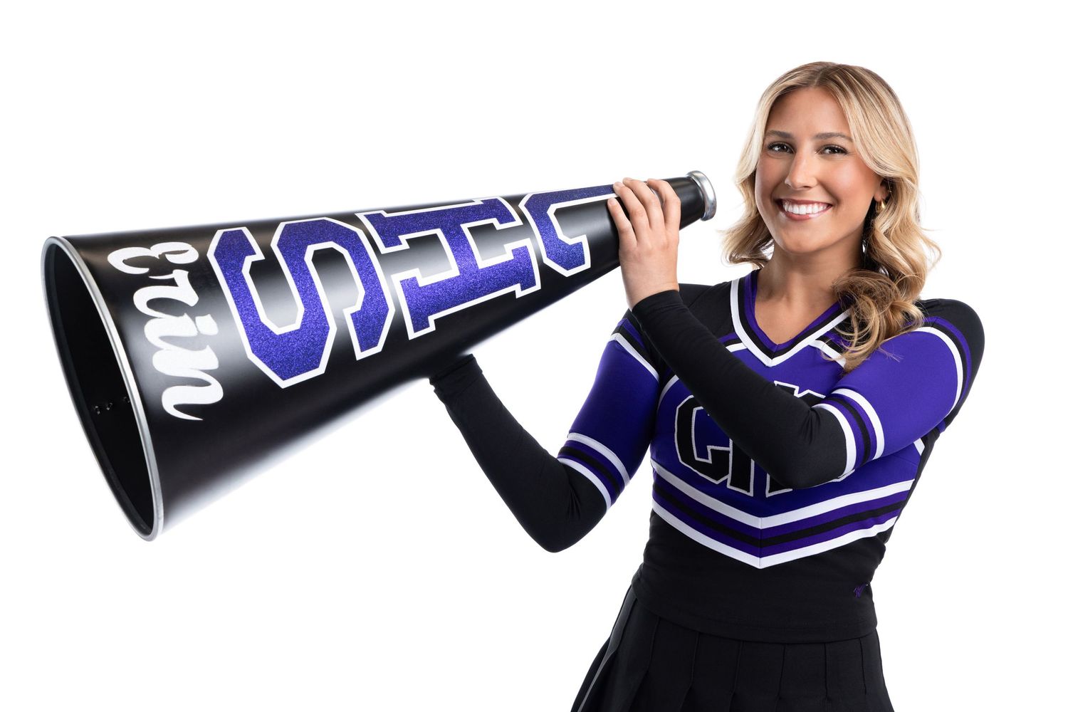 Cheerleader in purple uniform holds large megaphone smiling on white background.