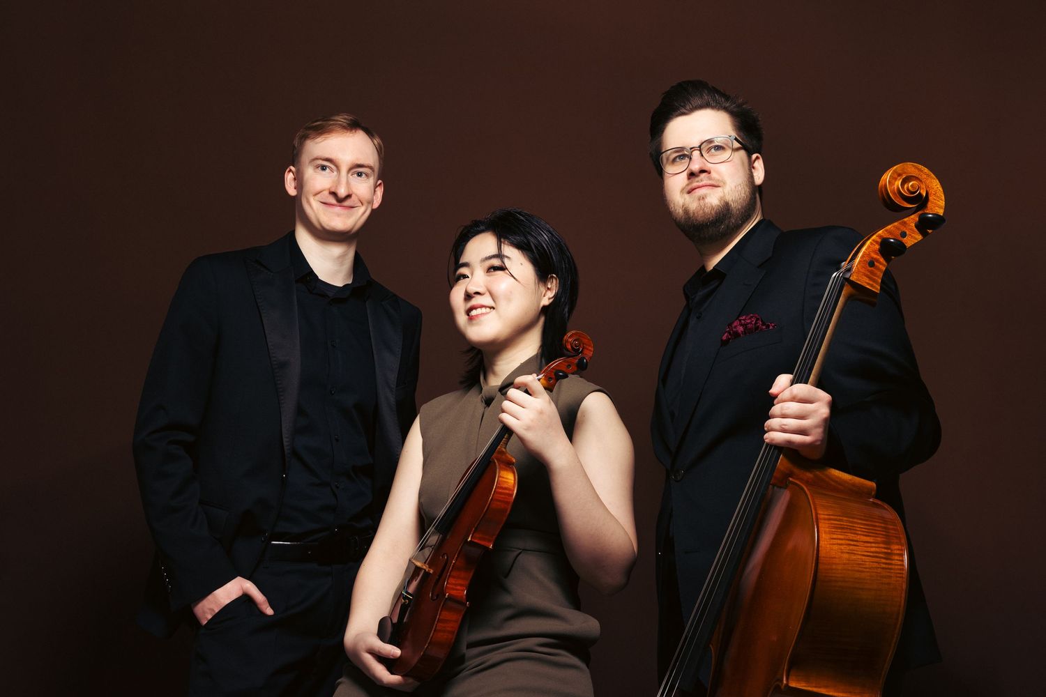 Portret trio z instrumentami smyczkowymi, zdjęcie promocyjne w studio na ciemnym tle