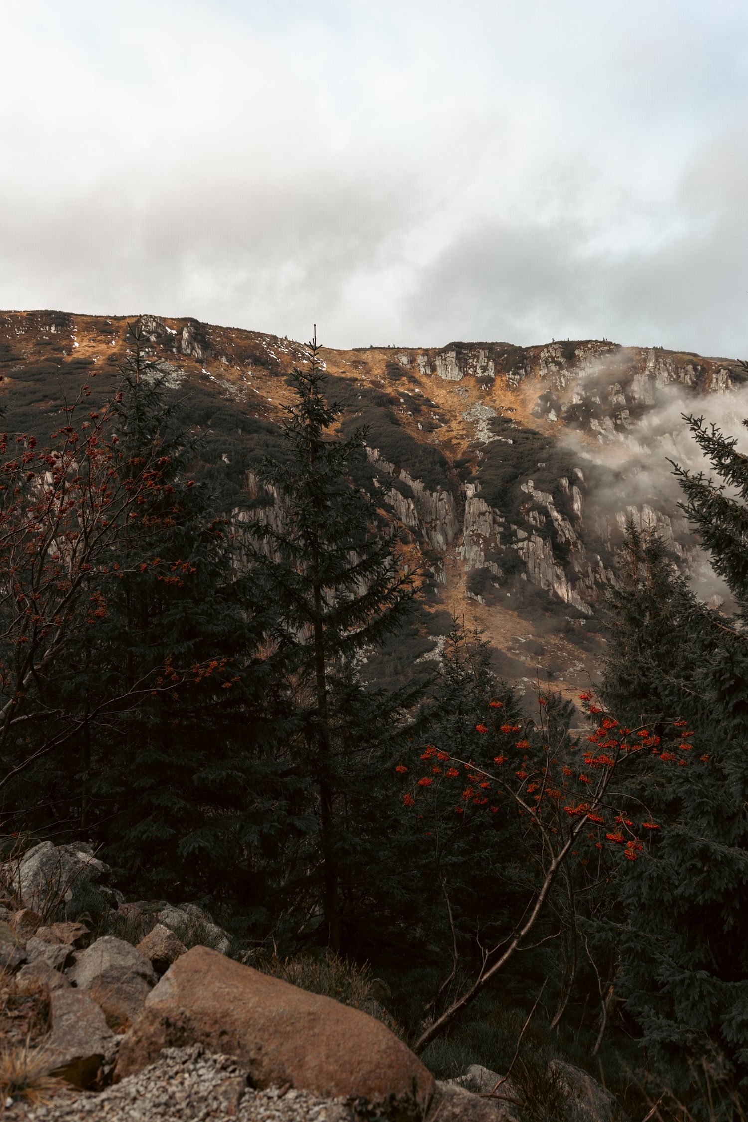 Górski krajobraz z chmurami i mgłą nad zboczami, fotografia natury; karkonosze