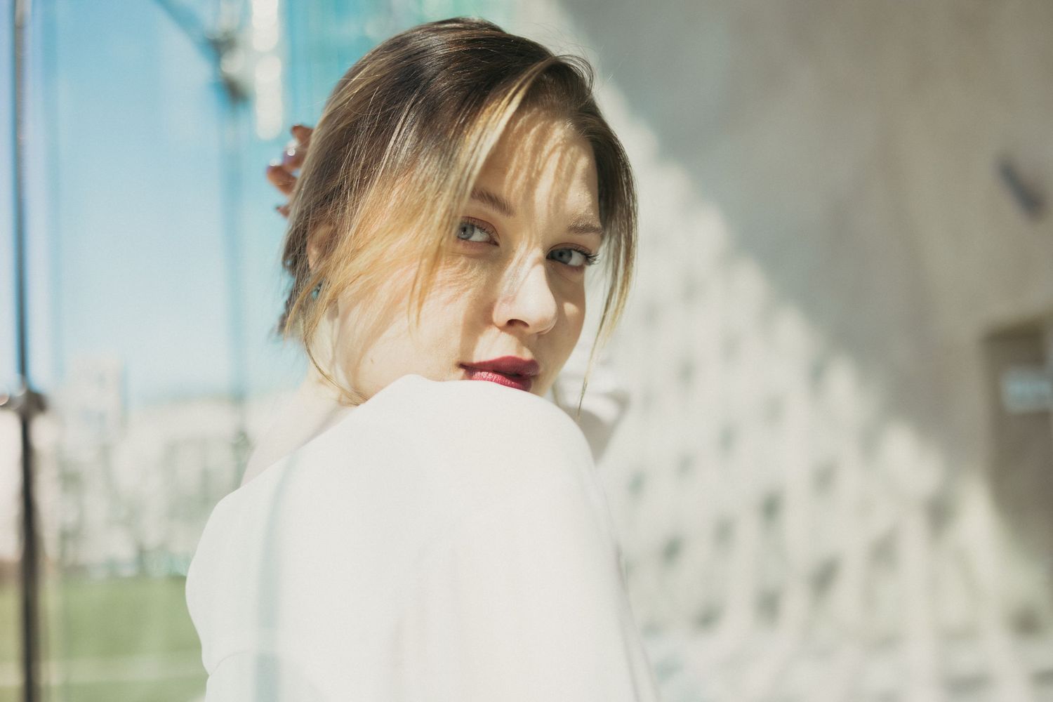 Portret kobiety w plenerze, spojrzenie przez ramię i miękkie światło dzienne
