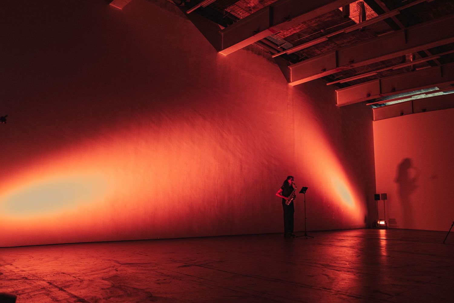 Minimalistyczne ujęcie sceny w czerwonym świetle, fotografia koncertowa solo
