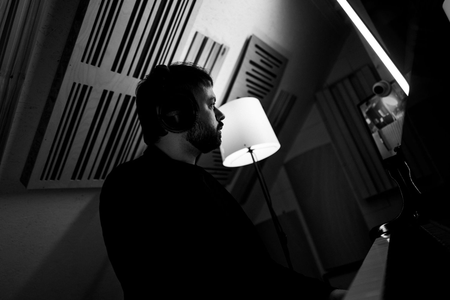 Czarno-białe ujęcie muzyka w studio nagraniowym, klimat backstage