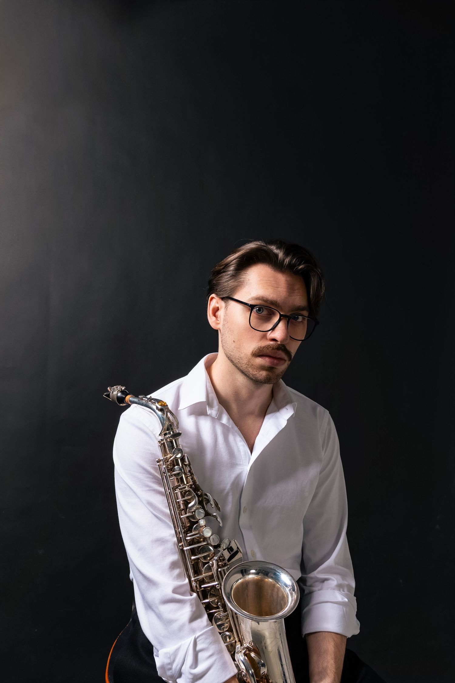 Portret mężczyzny w studio na ciemnym tle, elegancka stylizacja