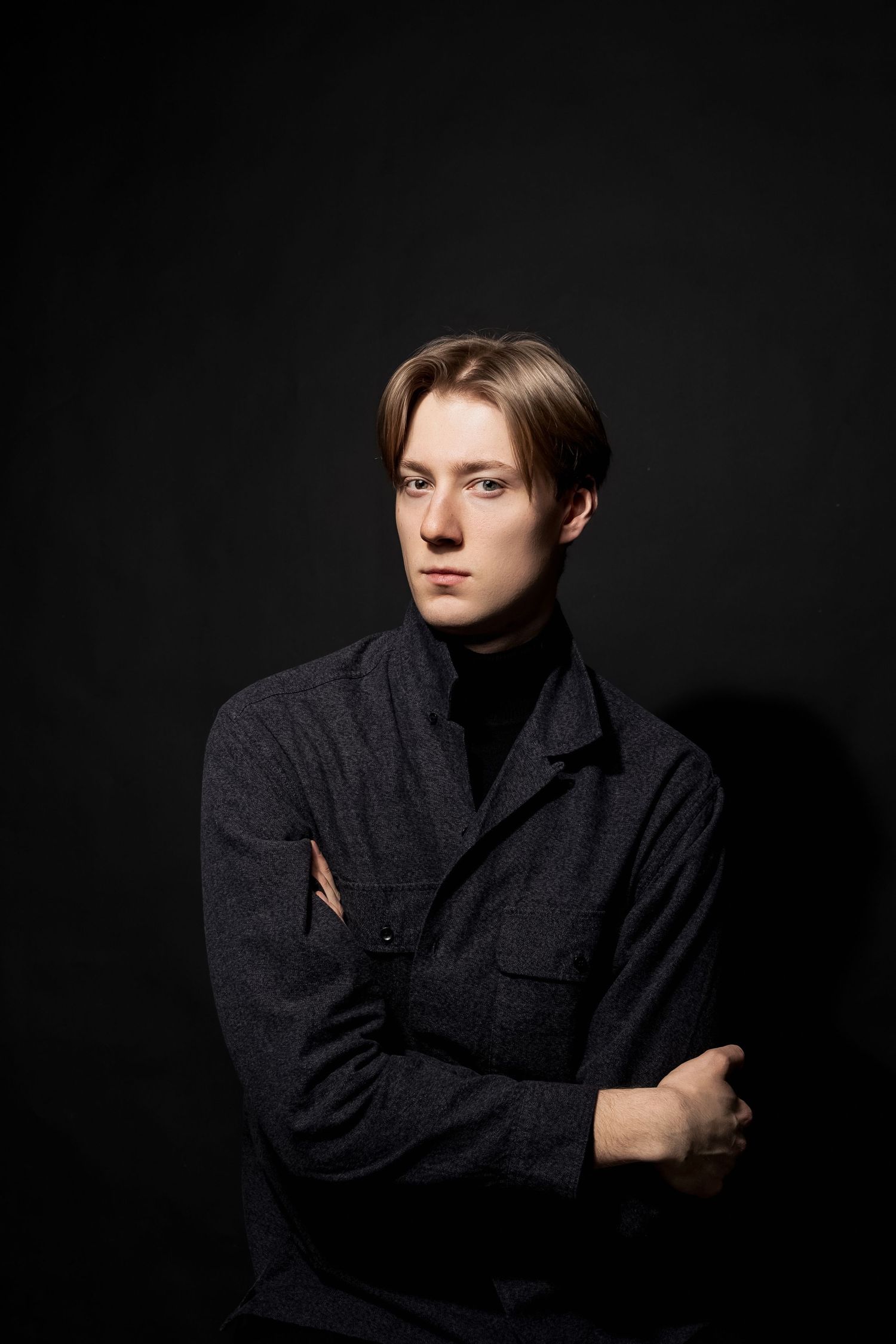 Studyjny portret mężczyzny na czarnym tle, elegancki klimat i kontrast