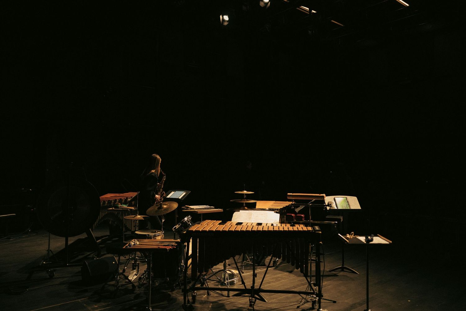 Koncert: scena z instrumentami perkusyjnymi w teatralnym świetle, fotografia wydarzenia