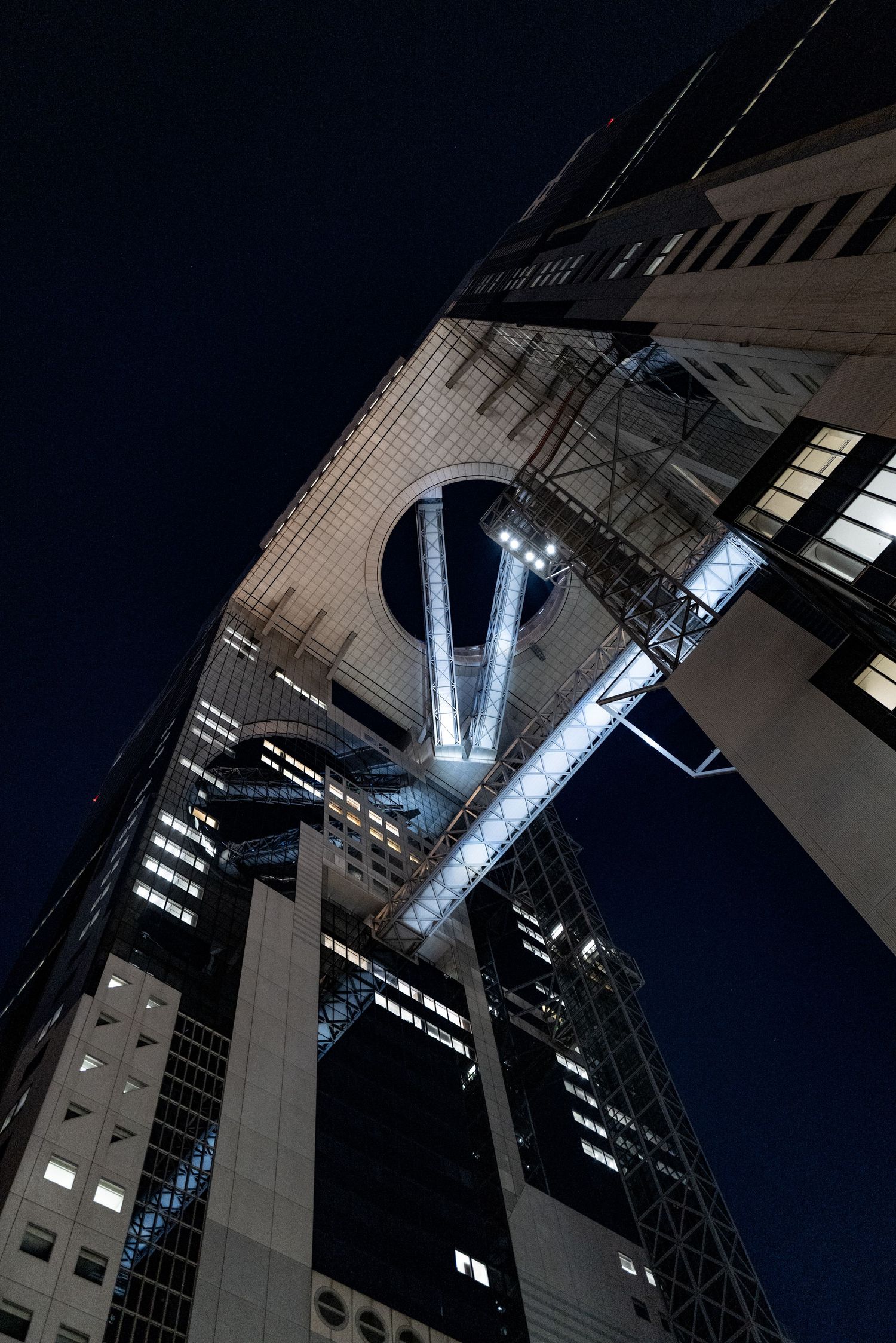 Nocne ujęcie nowoczesnej architektury z dołu, dynamiczna fotografia miasta; Osaka; Japonia
