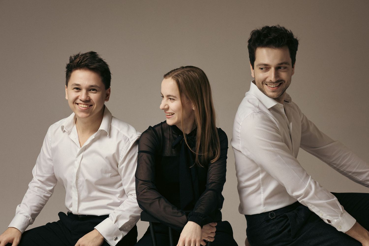 Portret trio w jasnej stylizacji na neutralnym tle, zdjęcie promocyjne zespołu