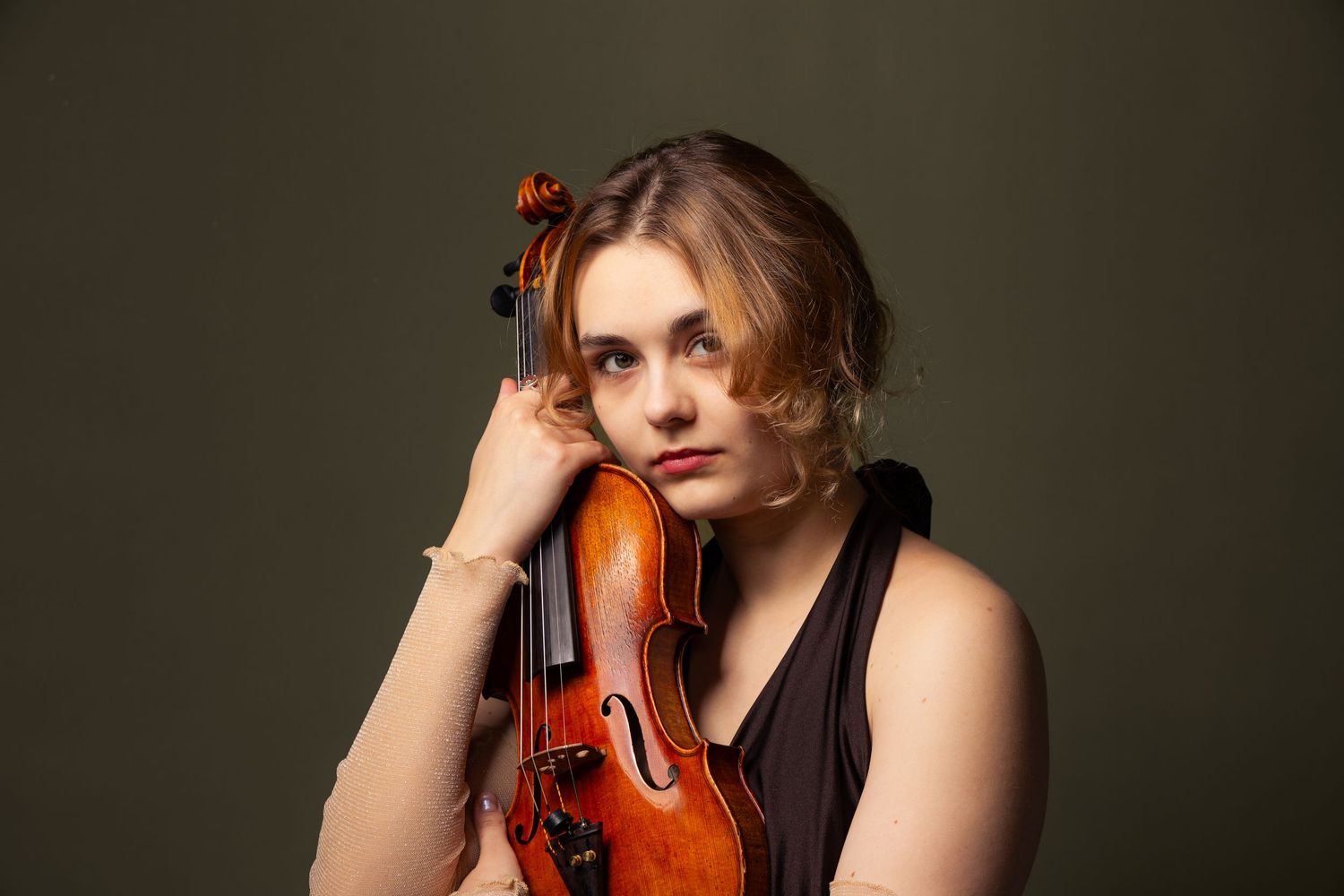 Portret skrzypaczki z instrumentem na ciemnym tle, studyjna sesja dla muzyków