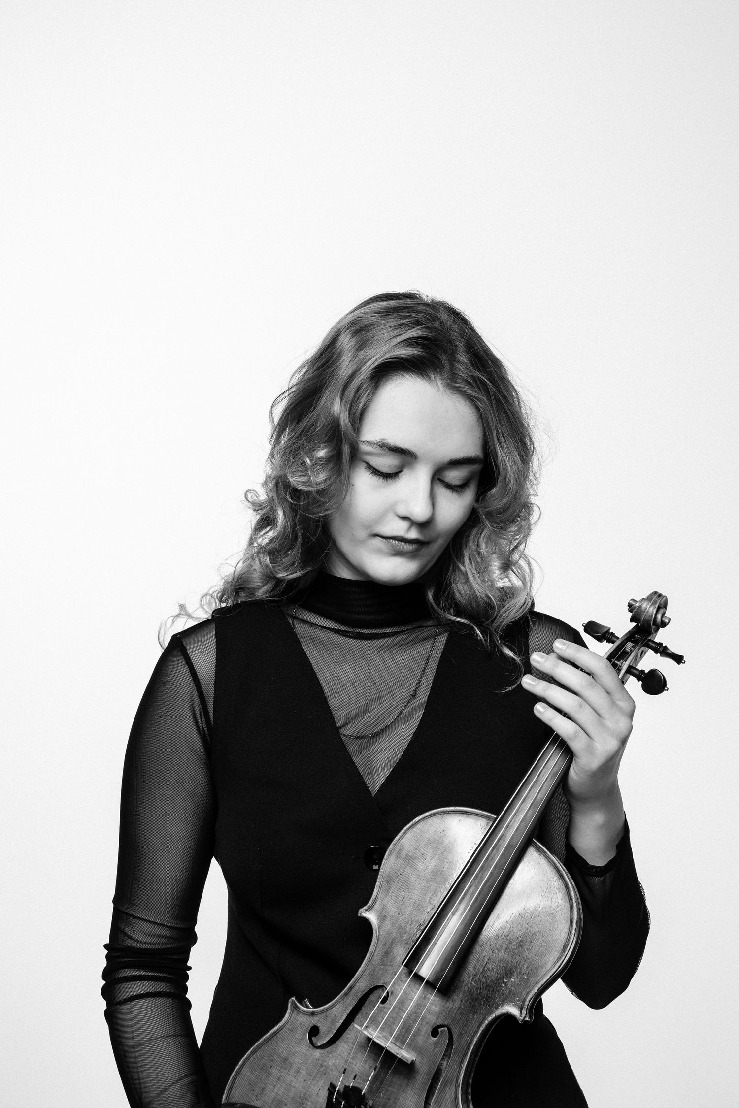 Czarno-biały portret skrzypaczki z instrumentem, minimalistyczne zdjęcie w studio