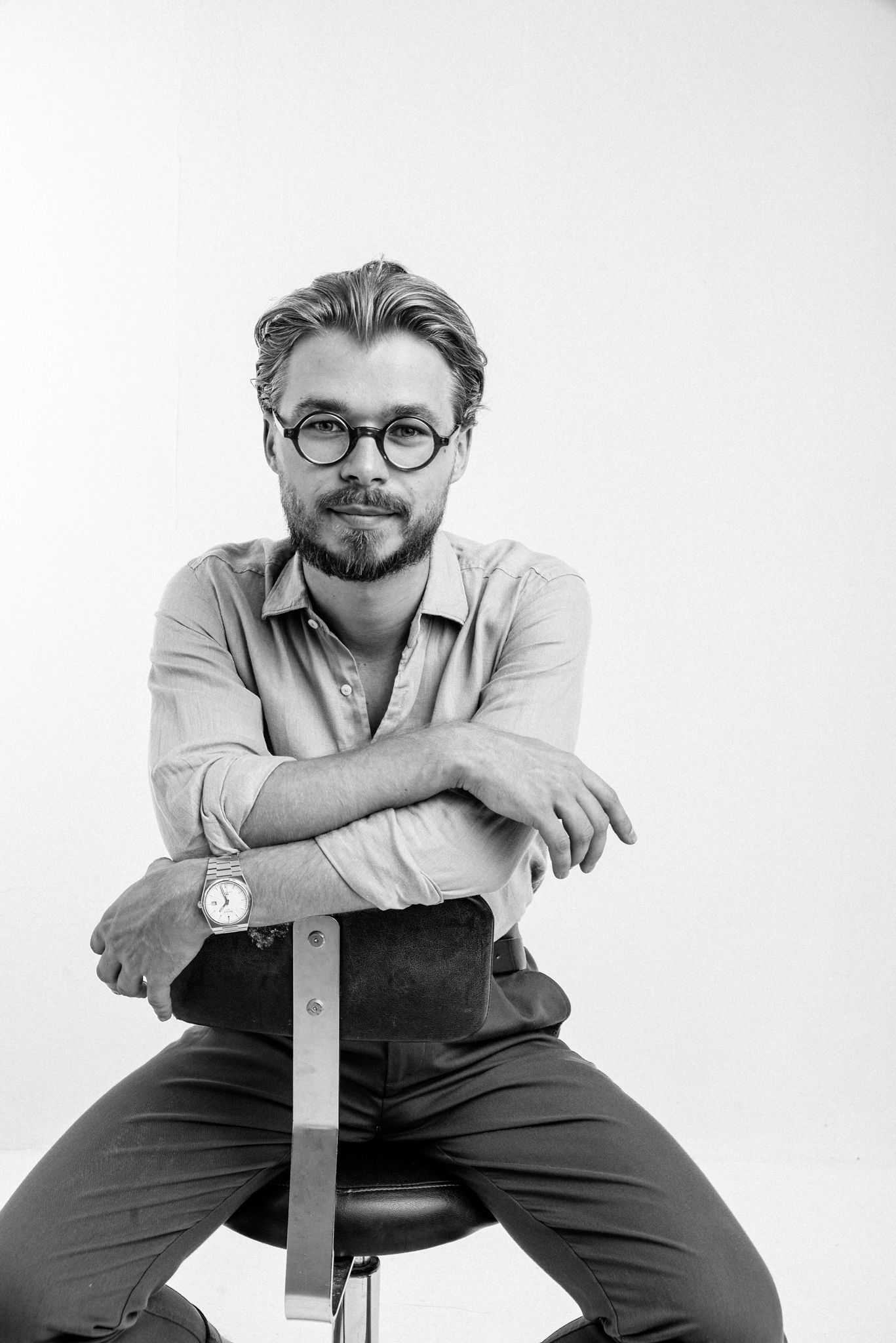 Czarno-biały portret mężczyzny w studio na jasnym tle, fotografia wizerunkowa