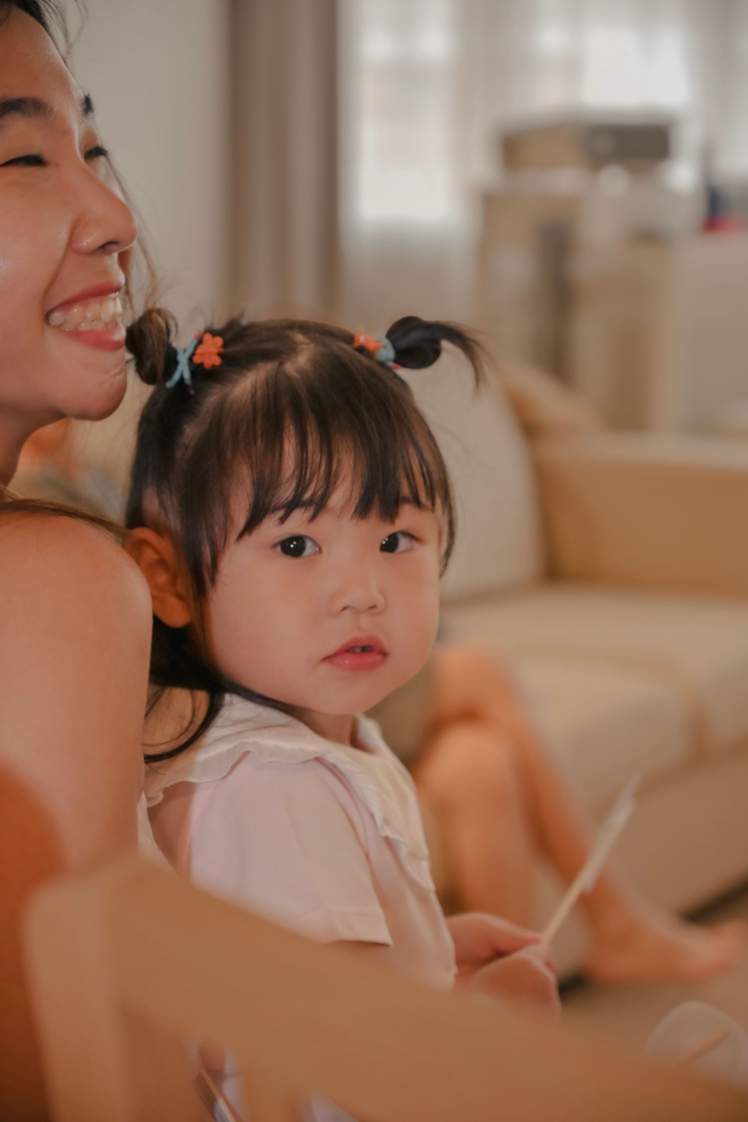 A toddler in a white dress at a gender reveal party celebration.