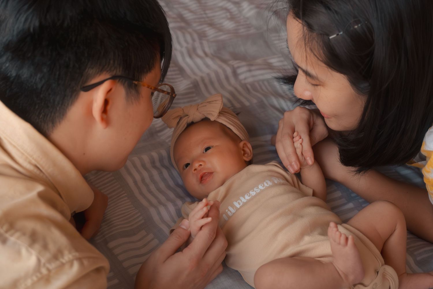 Intimate family moment with parents cuddling their baby.