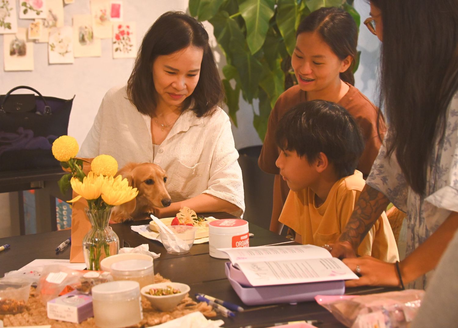 People gathered around tables at a social event with food and drinks.