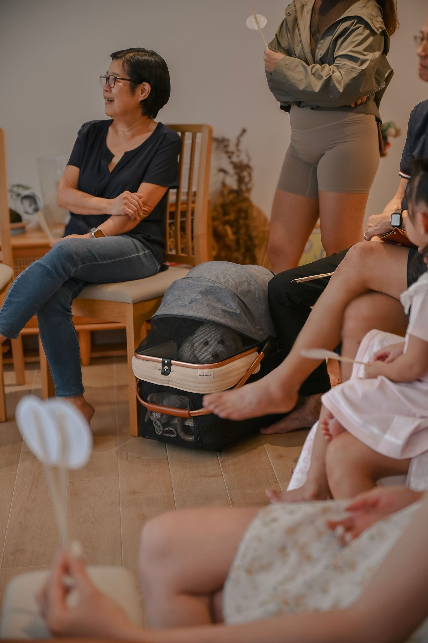 Group gathered in casual setting for indoor activity with backpacks and chairs visible.