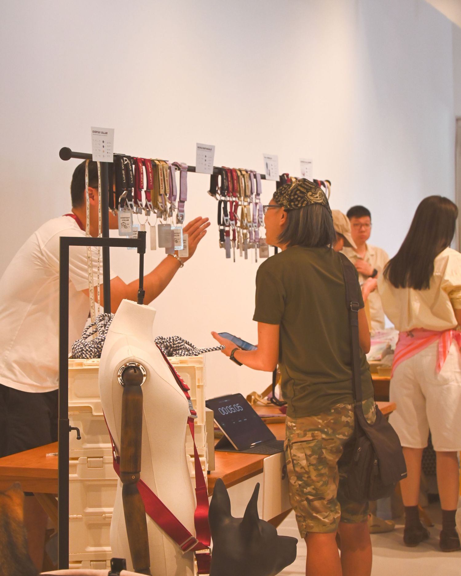 Customers browsing colorful straps and accessories displayed on a wall in a modern boutique shop.