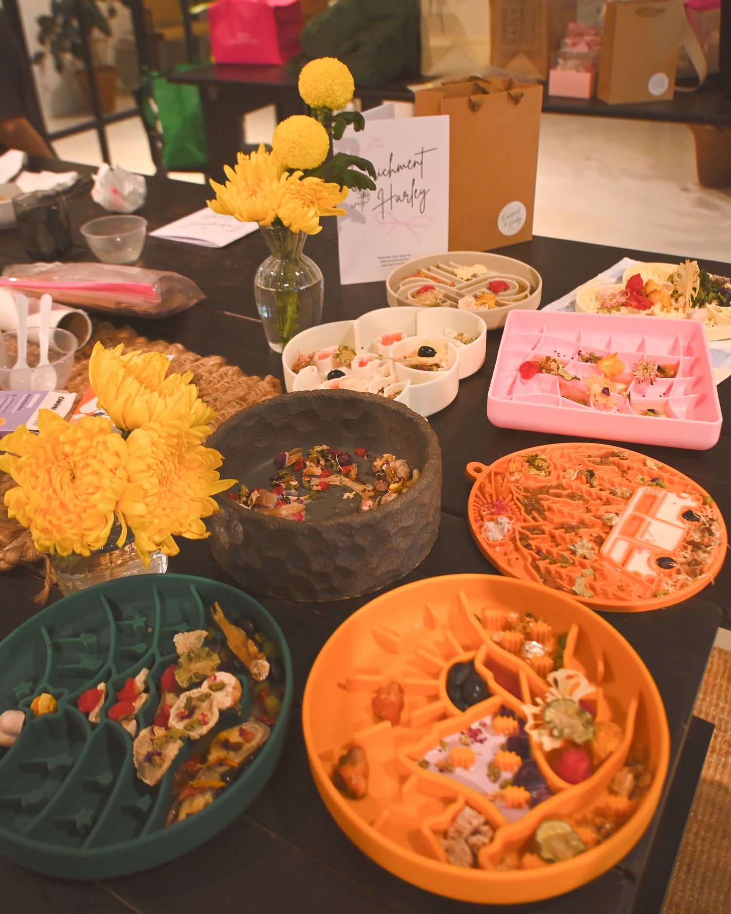 Colorful plates of food and snacks arranged on a dark table at a party.
