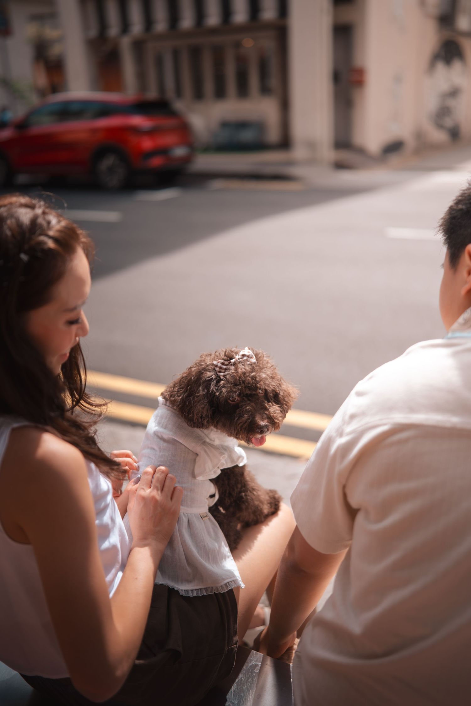 Three people sitting together outdoors sharing a meal on a sunny day.