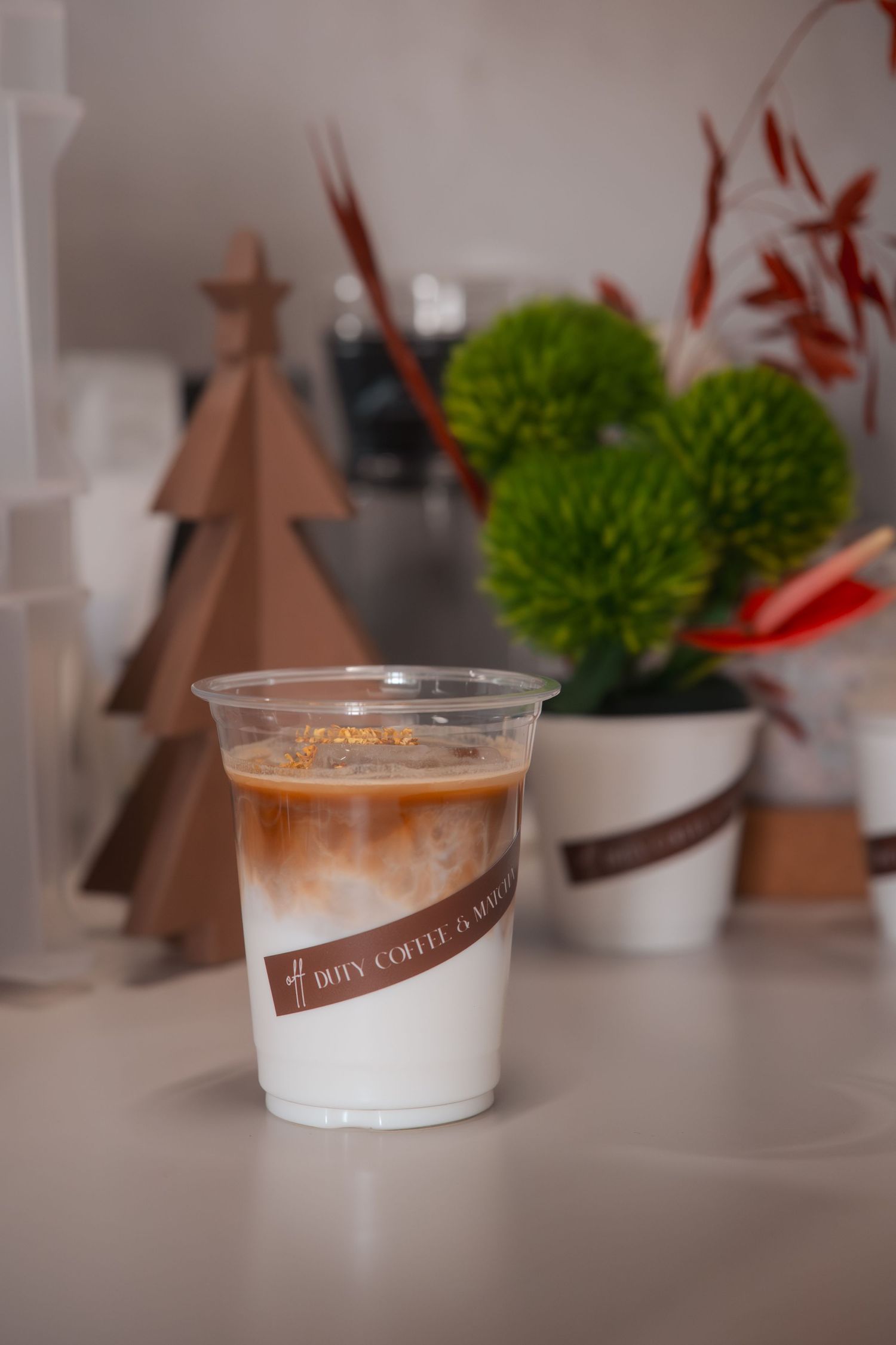 Sequence of photos showing a layered coffee drink with cream in a clear plastic cup against a holiday-themed background.