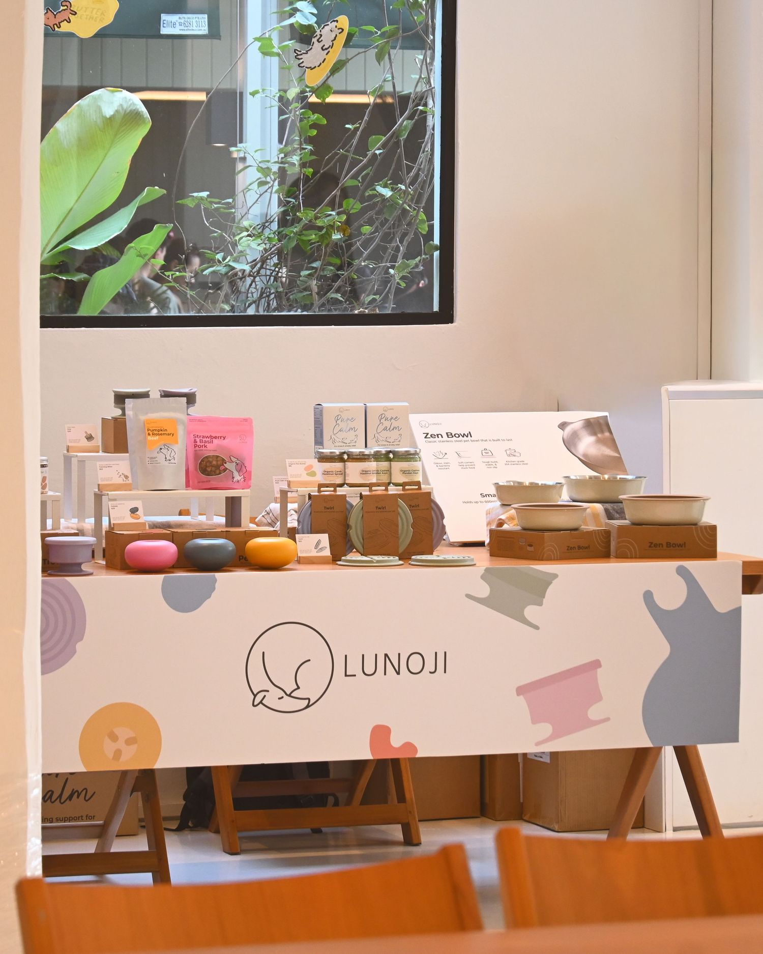 Interior of pet store with wooden furniture and Lunoji branding on wall.