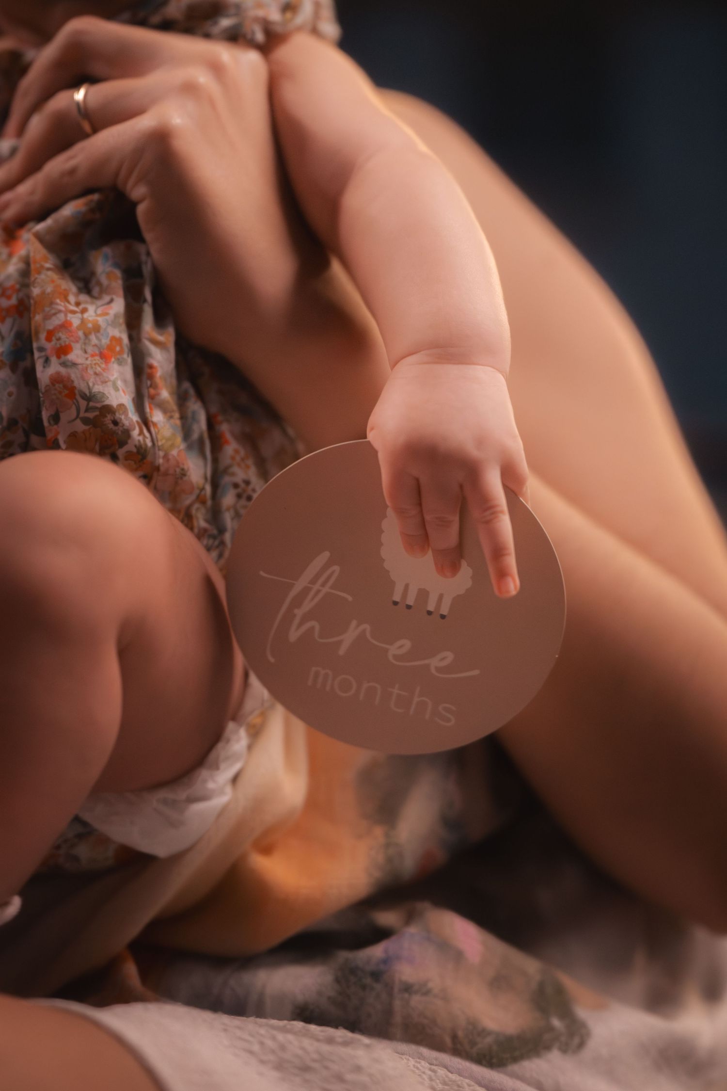 A series of cropped artistic maternity photos showing a pregnant belly against a dark background.