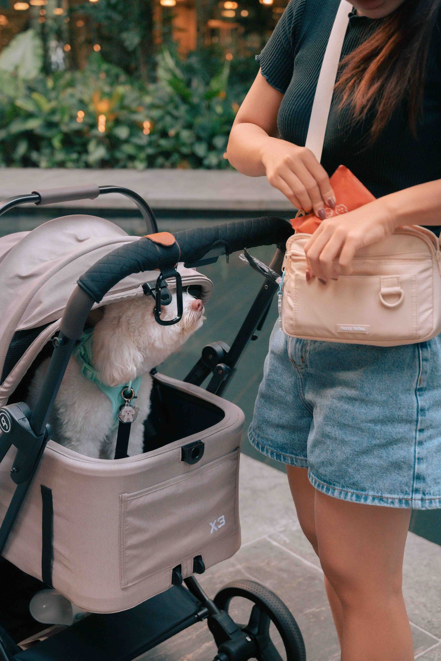 Demonstration of stroller bag features and compartments in an outdoor setting.