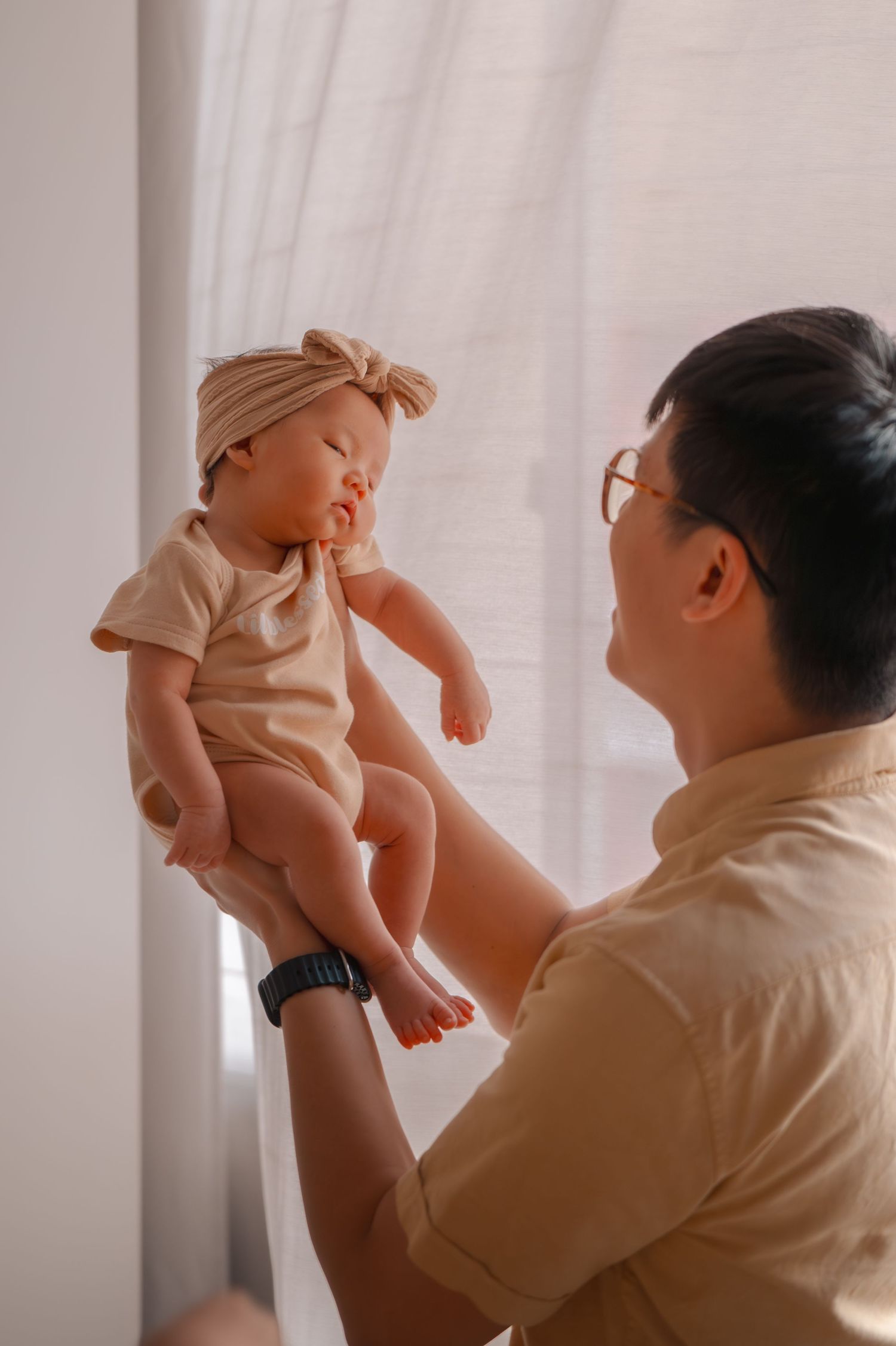 A tender moment with a baby being held up in the air.