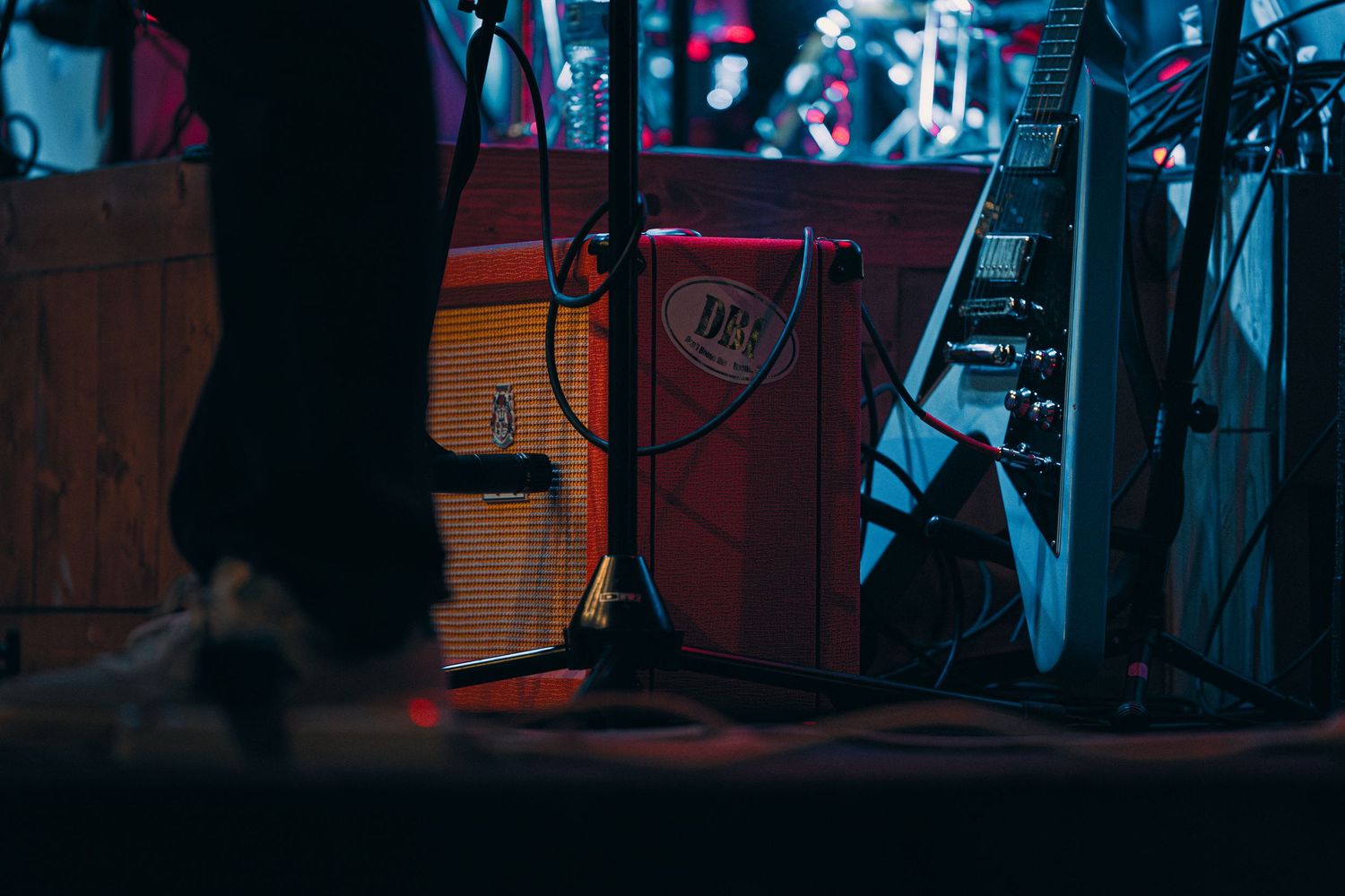 Music amplifiers and cables on a dimly lit stage during a live concert performance.