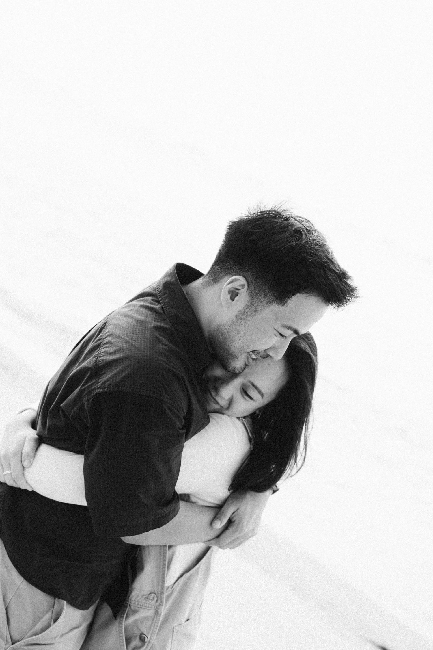 A tender black and white portrait of a couple embracing and sharing an intimate moment together.
