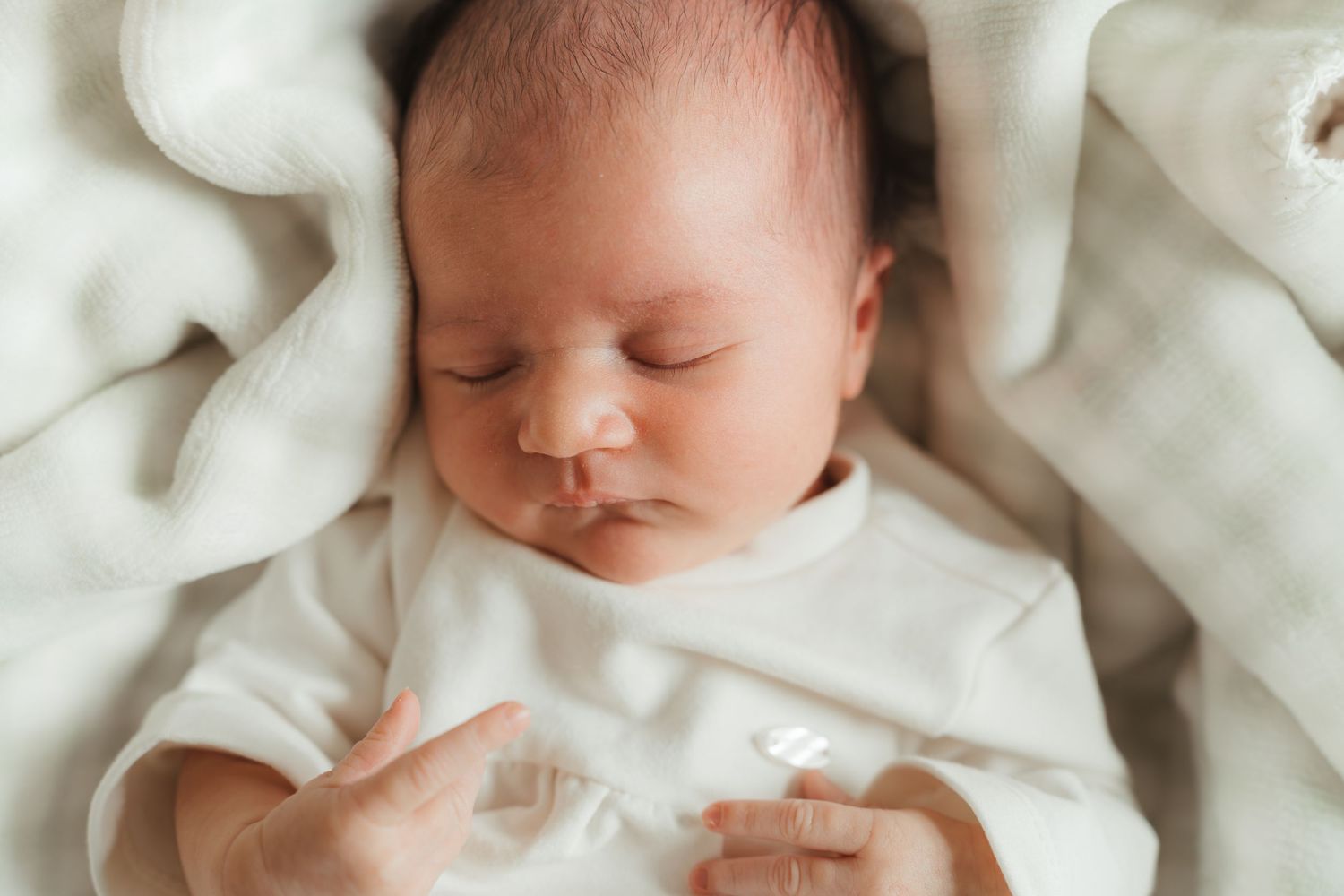 Sleeping newborn girl on a knit blanket during a Charlotte, NC lifestyle session at home.