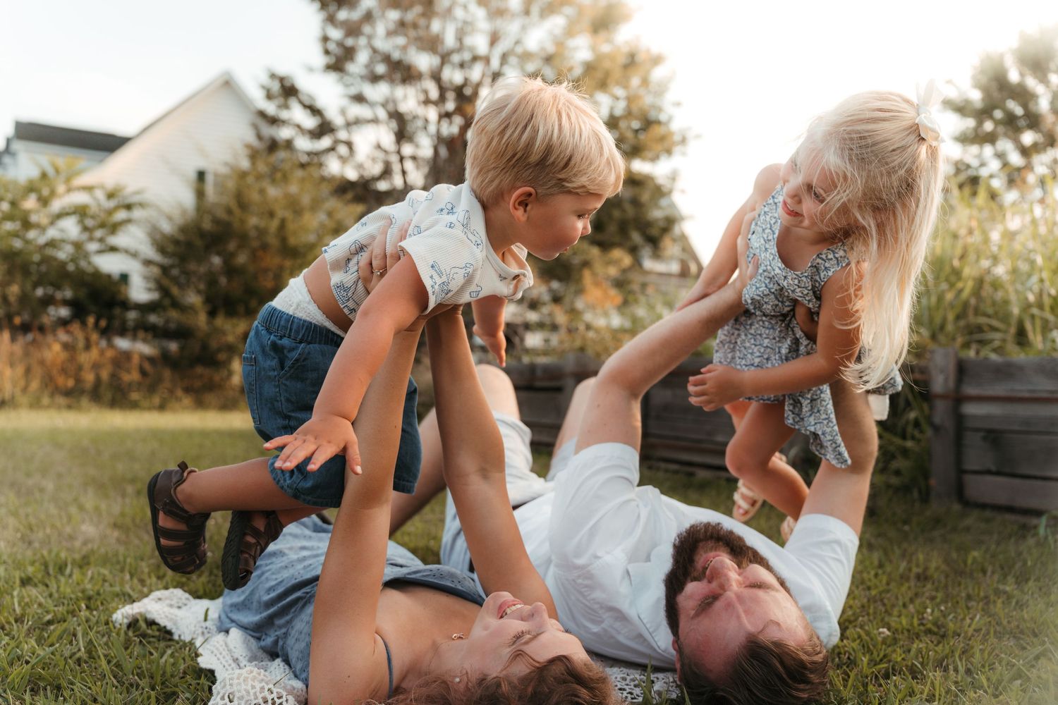 Parents lifting children into the air during an outdoor lifestyle family session at Five Blossoms Farm located in Clover, SC.